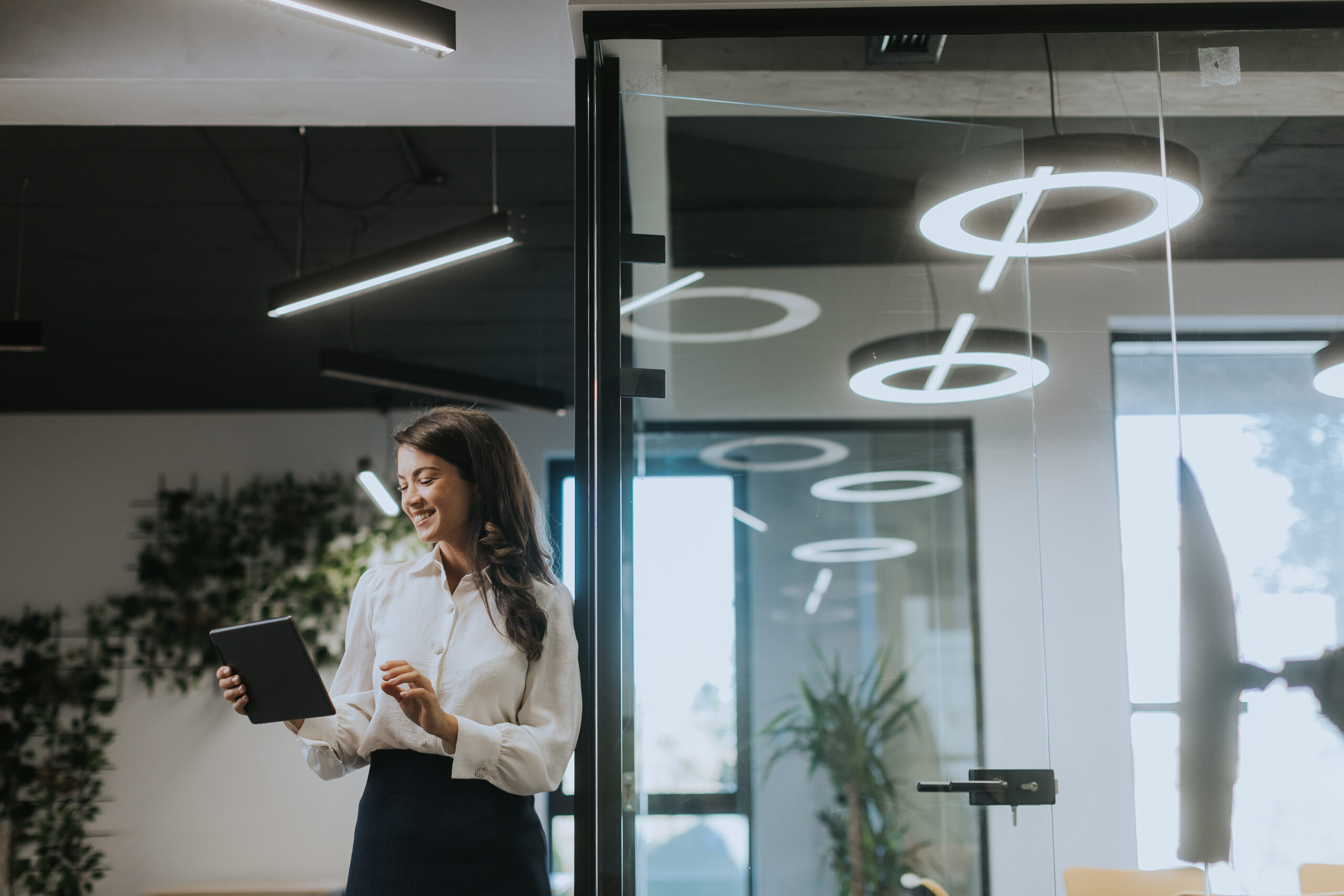 Young woman with digital tablet standing in the modern office